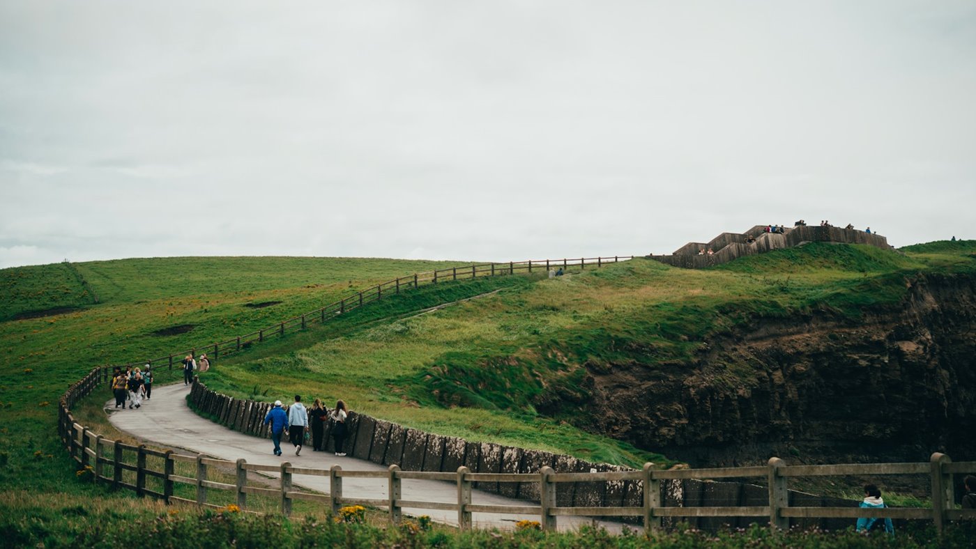 Walkers following a coastal cliff path with open sea views