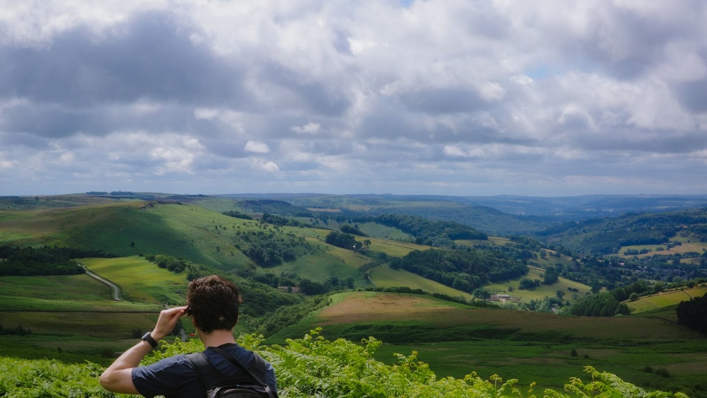 Hiker moving across rolling hills during a long walk