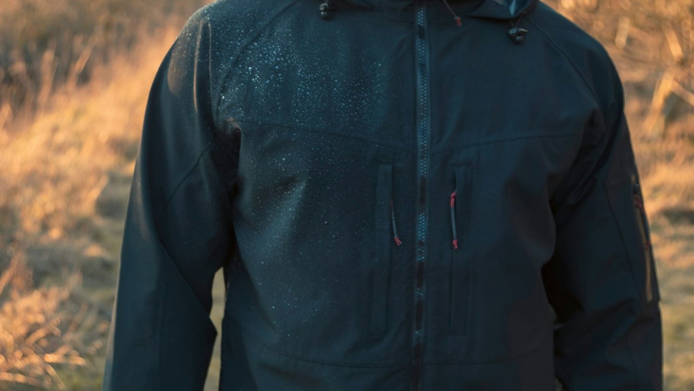 Walker wearing a dark waterproof jacket in countryside
